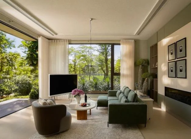 Model villa living room - floor-to-ceiling glass overlooking the forest